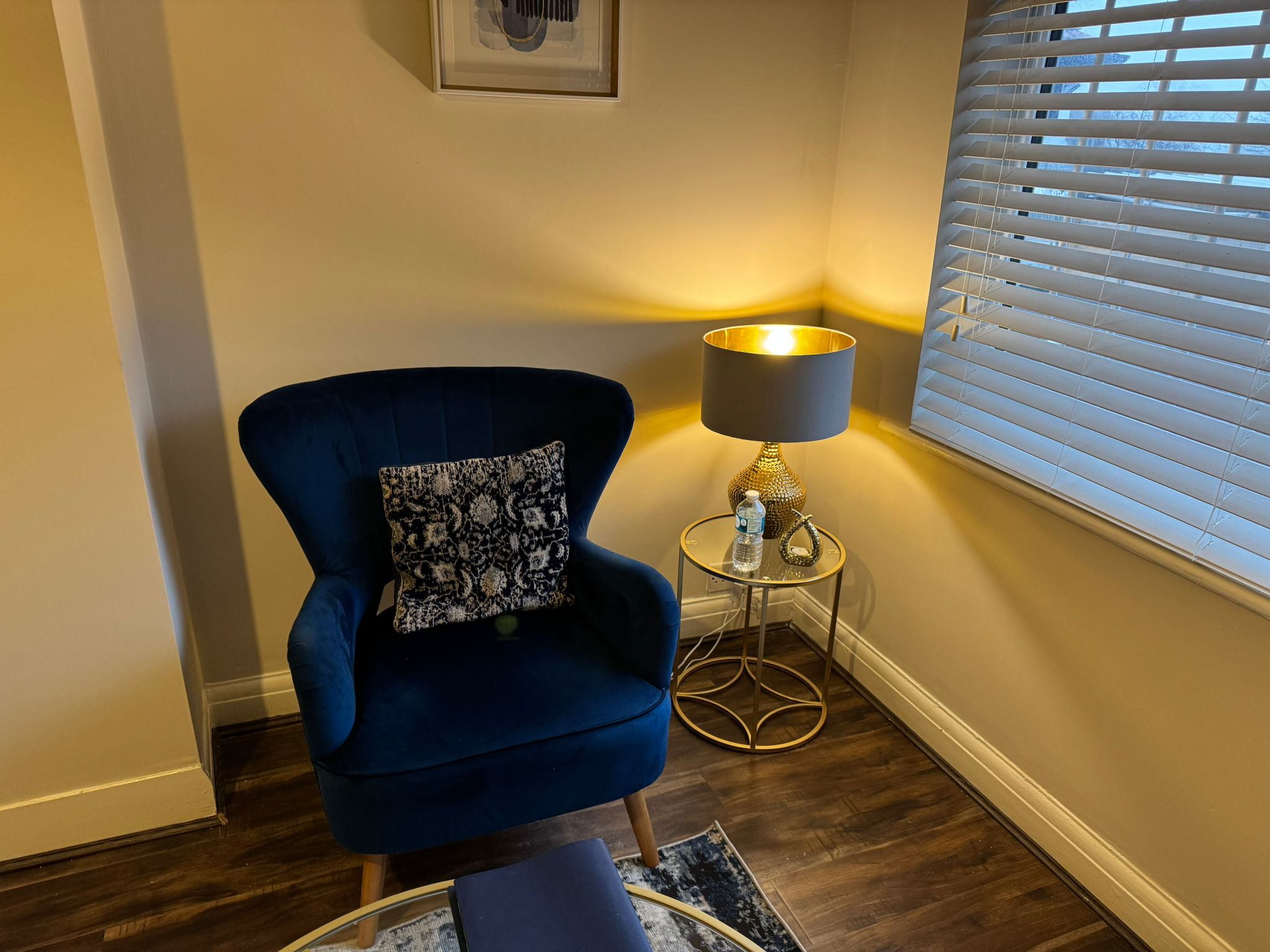 A cosy armchair beside a warmly lit lamp in the therapy room